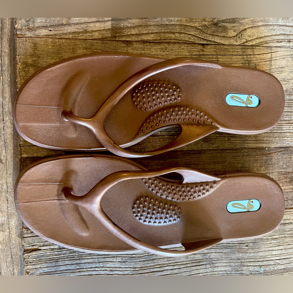 Lightly worn bronze Oka B flip flops